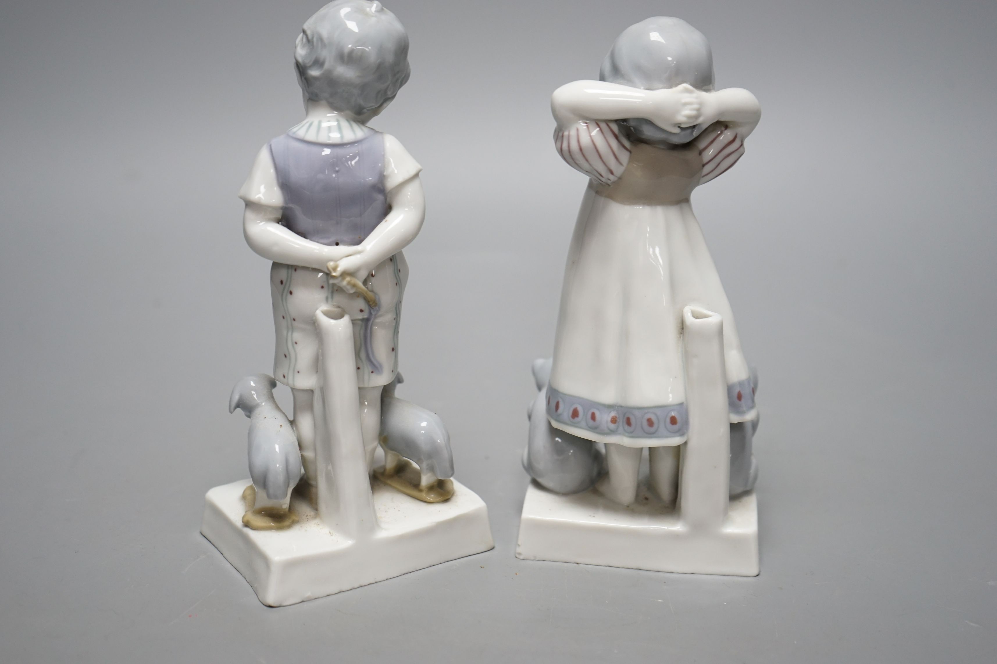 Teddy bear & Steiff collector’s interest - a pair of 1920s German Goebel porcelain figures of a girl and two teddy bears and a boy with two pull-along sheep on wheels, 17cms high